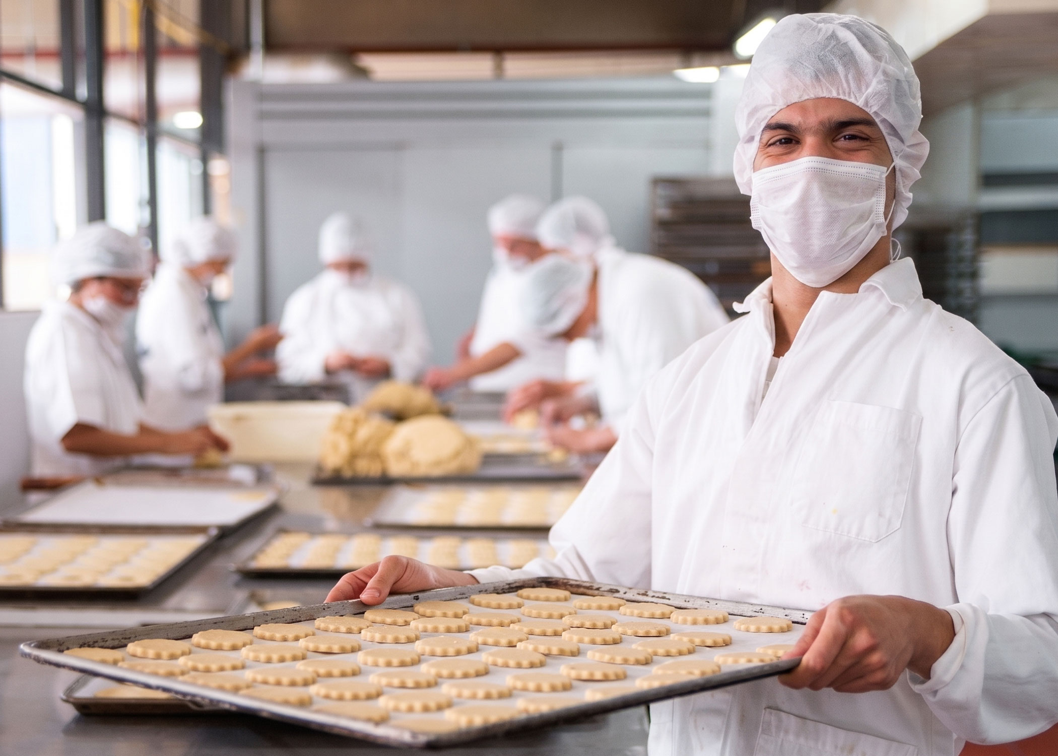 Joven preparando galletas en taller de panadería