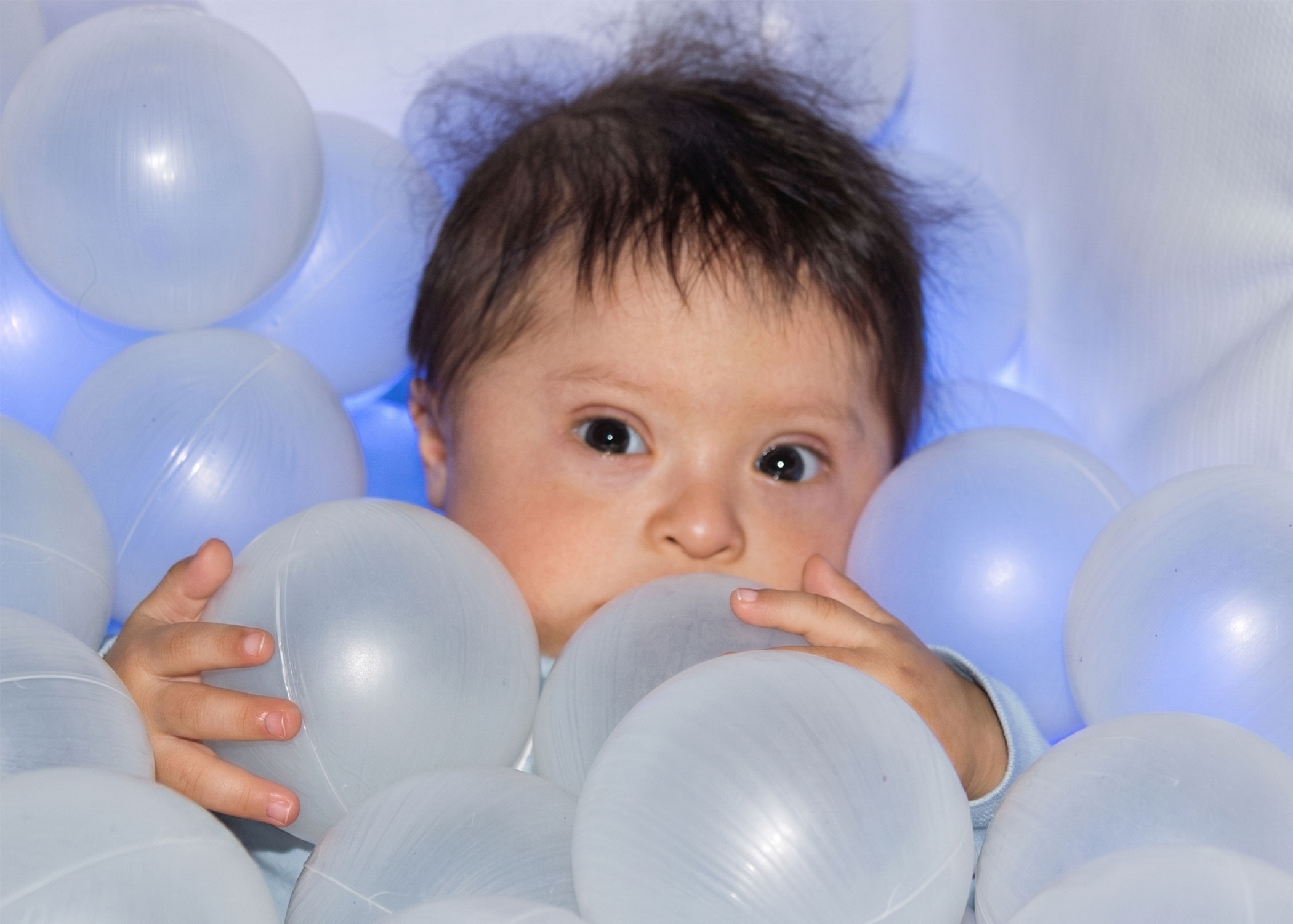 Bebé en alberca de pelotas con estimulación multisensorial
